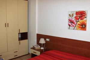 a bedroom with a red bed and a painting on the wall at Hotel Villa Argentina in Riomaggiore
