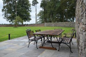 a wooden table and chairs with a park in the background at Rectory Cottage. Close to Enniskillen and lakes. in Enniskillen