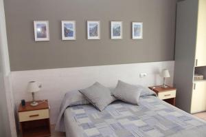 a bedroom with a bed with three pictures on the wall at Hotel Villa Argentina in Riomaggiore