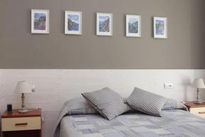 a bedroom with a bed with four pictures on the wall at Hotel Villa Argentina in Riomaggiore