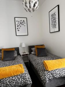 1 dormitorio con 2 camas y lámpara de araña en Rectory Cottage. Close to Enniskillen and lakes., en Enniskillen
