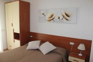 a bedroom with a bed with a picture of birds on the wall at Hotel Villa Argentina in Riomaggiore
