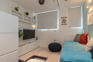 salon z kanapą i telewizorem w obiekcie [Sweet apartment] - Grazioli 2 w Mediolanie