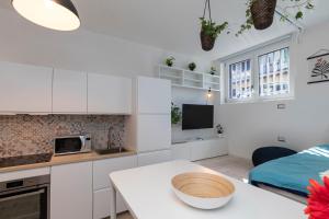 kuchnia z białymi szafkami i stołem w pokoju w obiekcie [Sweet apartment] - Grazioli 2 w Mediolanie