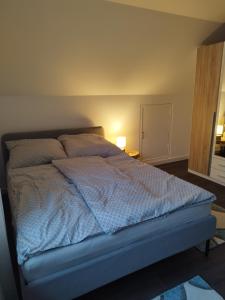 a bed with a blue comforter in a bedroom at Ferienhaus in Handewitt kurz vor dänischen Grenze in Handewitt
