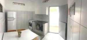 マラゴージにあるCasa Maria Bonitaの白いキッチン(テーブル、冷蔵庫付) +7枚の写真