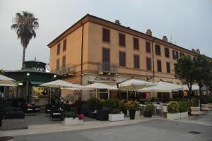 a building with tables and umbrellas in front of it at Ex Dogana Home in Fiumicino