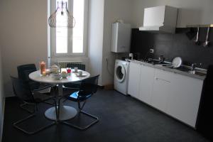 a kitchen with a table and a washing machine at Ex Dogana Home in Fiumicino +11 photos