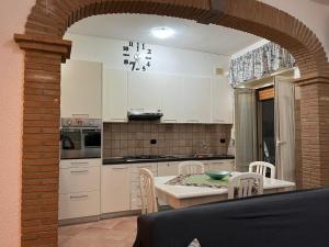 a kitchen with white cabinets and a table and chairs at LA CASA DI FLO in Anzio