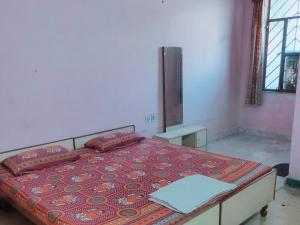 a bedroom with a bed with a red bedspread and a mirror at Jwala Niketan Guesthouse Private rooms in Jaipur