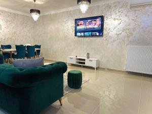 a living room with a couch and a tv on the wall at Mrs Smart Luxury Apartament in Ploieşti