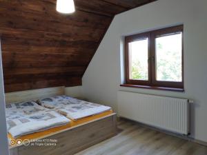 1 dormitorio con cama y ventana en Chata pod lipou Bobrovník, en Bobrovník