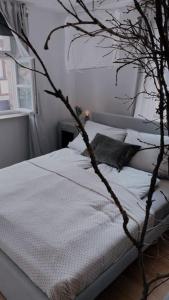 a bedroom with a white bed with a tree at Altstadtjuwel in Cadolzburg- Hidden by Feingemacht in Cadolzburg