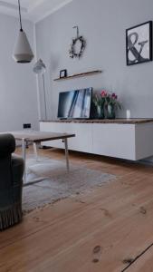 een woonkamer met een tafel en een televisie bij Altstadtjuwel in Cadolzburg- Hidden by Feingemacht in Cadolzburg