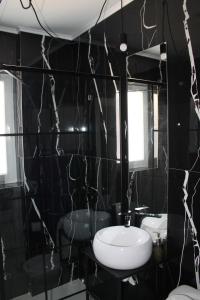 a black bathroom with a sink and a mirror at Studio cu grădina proprie in Popeşti-Leordeni +10 photos