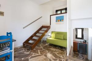 a living room with a green couch and stairs at Captain's Beach Apartments in Kissamos