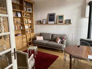 sala de estar con sofá y mesa en Belle maison de famille en Usson-en-Forez