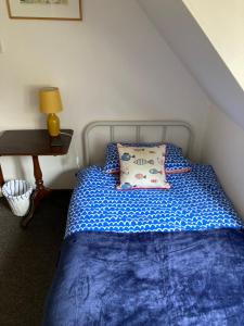 um quarto com uma cama azul com uma almofada e uma secretária em 5 Stable Cottages , Hartington Road, Cromer.North Norfolk. NR27 0EJ em Cromer