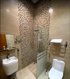 y baño con ducha, aseo y lavamanos. en ال متعب سويتس التراثي en Riad