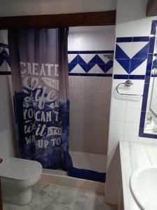 a bathroom with a toilet and a shower curtain at Aldea del Mar in Torrevieja