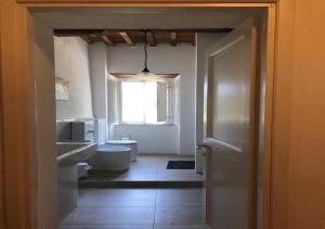 łazienka z toaletą i oknem w obiekcie B&B Giardino delle Camelie w mieście Capannori