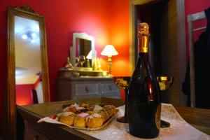 una botella de vino y un plato de comida en una mesa en Dimora il Bacio 2, en Anagni