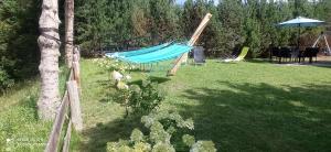 a hammock in a yard next to a tree at Chatka Leo in Fornetka