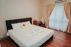 um quarto com uma cama com lençóis brancos e pássaros em Gee homestay em Kota Kinabalu