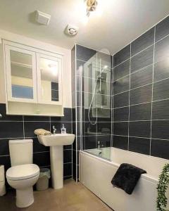 a bathroom with a toilet and a sink and a tub at Loch Leven Getaway - 2 bed house in Kinross