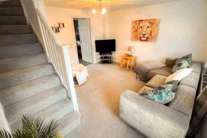 a living room with a couch and a staircase at Loch Leven Getaway - 2 bed house in Kinross