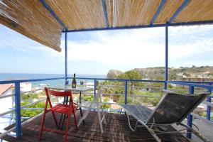 a balcony with a table and chairs and the ocean at Paradis Studios in Archangelos