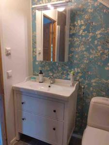 a bathroom with a sink and a mirror at Guesthouse Onnia, kattohuoneisto Siurossa in Siuro