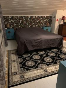 1 dormitorio con cama y alfombra en el suelo en Guesthouse Onnia, kattohuoneisto Siurossa, en Siuro