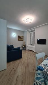 un salon avec un canapé bleu et une télévision dans l'établissement LA CASA DI IA, à Vernazza