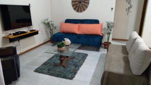 sala de estar con sofá azul y mesa en Morada das Águas Campinho Maraú BA, en Maraú