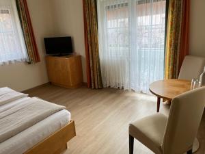 um quarto com uma mesa e uma cama e uma mesa e cadeiras em Hotel Altneudörflerhof em Bad Radkersburg