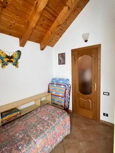 1 dormitorio con 1 cama y una mariposa en la pared en Attico sul Rosa en Ceppo Morelli