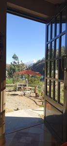 Une porte ouverte s'ouvre sur une terrasse avec une table de pique-nique. dans l'établissement Ecolodge Casa del Montañista, à Huaraz