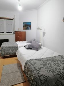 PENICHE - Guest House Casa das Estelas في بينيش: غرفة نوم بسريرين وخزانة
