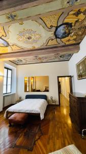Appartamento La Corte في أوليدجو: غرفة نوم مع سرير كبير مع لوحة على السقف
