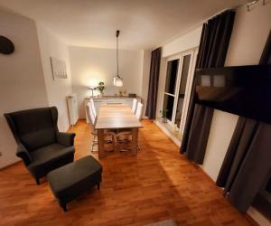 uma sala de estar com uma mesa de madeira e cadeiras em Komfortable Ferienwohnung Auf dem Höchsten em Dortmund