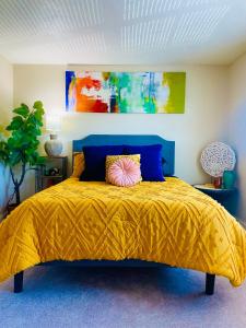 a bedroom with a yellow bed with a blue head board at Cozy Short & Suite 4-Bedroom Stay- Minutes to City in Quincy