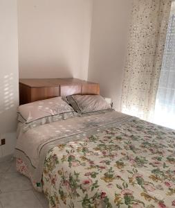 1 dormitorio con 1 cama con colcha de flores en 'Panta rei', en Mentana