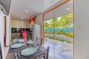 ein Esszimmer mit einem Tisch und einem großen Fenster in der Unterkunft Villas Mapache del Caribe in Puerto Viejo