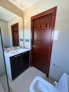 baño con aseo y puerta de madera en El Diablo Chic - Style House, en Punta del Diablo