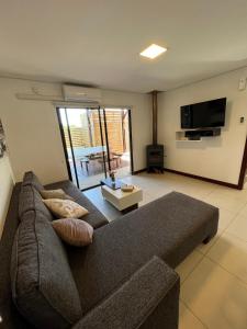 sala de estar con sofá y TV en El Diablo Chic - Style House, en Punta del Diablo