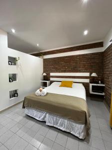 una camera con letto e muro di mattoni di La Quinta Departamento a Santa Rosa