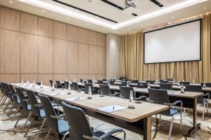 a conference room with tables and chairs and a projection screen at Citadines Abha in Abha