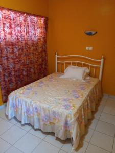 a bed sitting in a room with a window at Hotel Sol Marina in Tarrafal