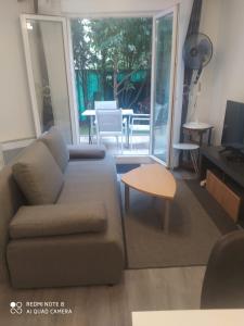ein Wohnzimmer mit einem Sofa und einem Tisch in der Unterkunft Moderne & LUXURY T2 Paris la défense in Puteaux
